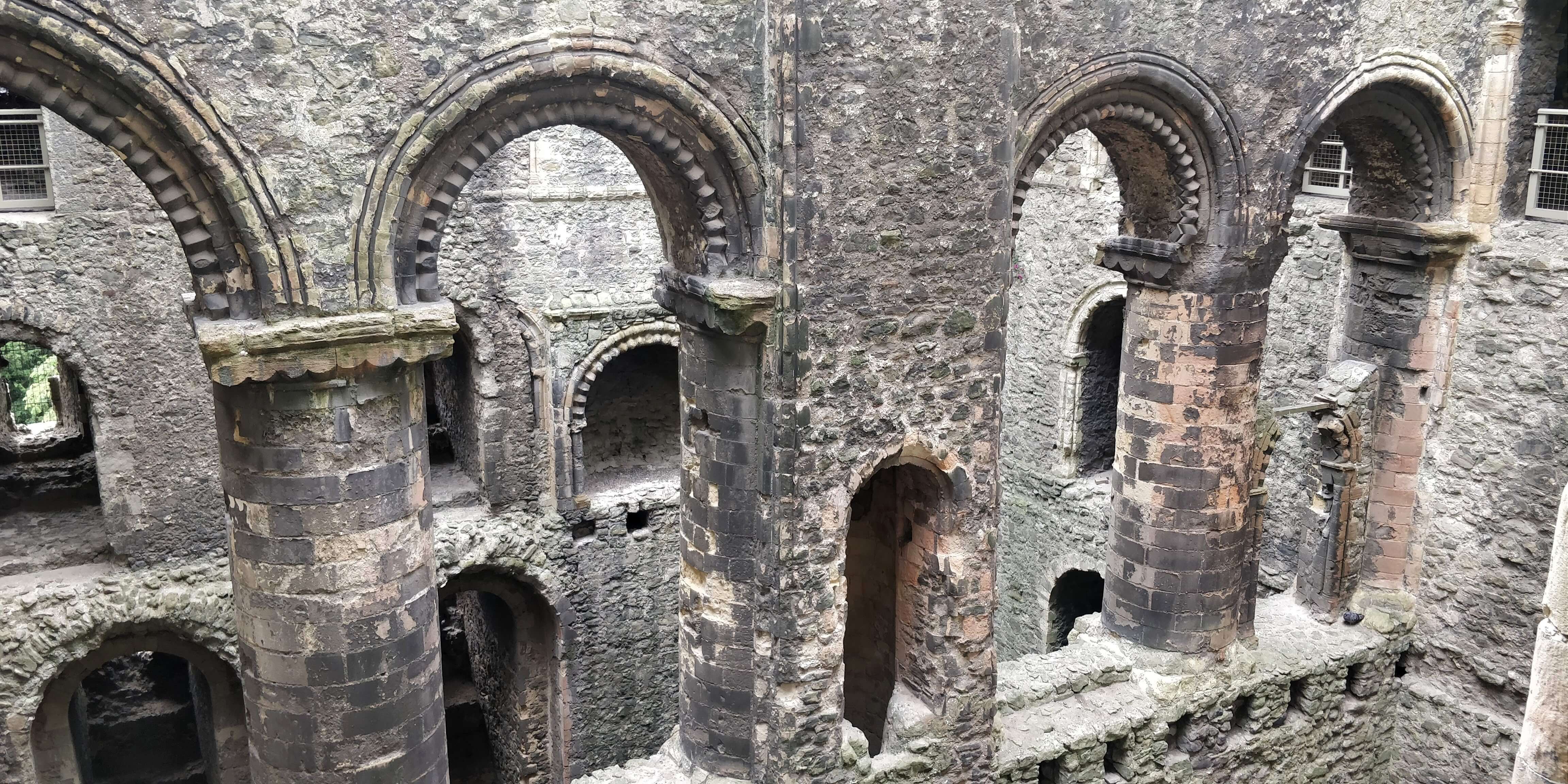 The crosswall of the keep, with four archways and the well shaft in the middle. Through the archways you can see the windows and doorways of the other half of the keep.